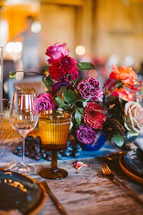 Ruby, amethyst, and sapphire hues may feel luxe, but Lale Florals proved that they work for rustic weddings, too. The pros arranged this unique centerpiece of red and purple roses and dahlias, which popped against the raw wood tables. Topaz glassware and sapphire vases ensured every gemstone color was represented. Dahlia Centerpiece Wedding, Peonies Wedding Centerpieces, Pop Wedding, Lush Wedding, Lighted Centerpieces, Jewel Tone Wedding, Boda Mexicana, Jewel Wedding, Floral Event Design