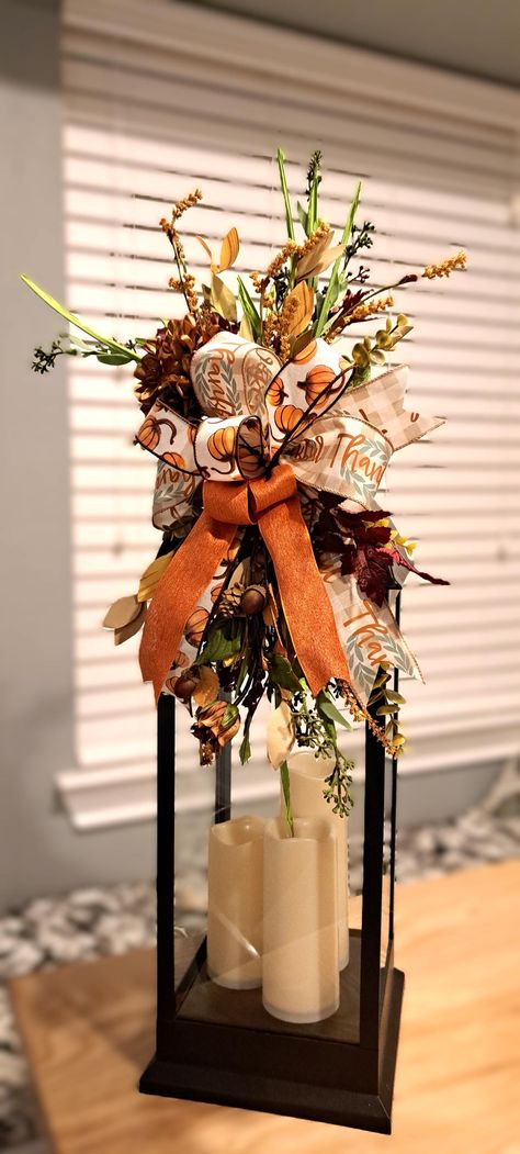 Add seasonal charm with a stunning Lantern Swag! Multiple fall options to choose from and each piece features a blend of rich, seasonal elements. Floral picks and leaves with luxurious flowers adds a touch of elegance. Each swag bring a natural, woodland feel, making either swag perfect for cozy fall decor. Layers of  wired ribbons with shades of orange, brown, yellow, green, and hint of blue add depth and texture. Ribbon colors will vary per piece design. Whether you're looking to adorn a lante Fall Decorated Lanterns Ideas, Fall Candlestick Arrangements, Fall Lamp Post Decorations, Fall Birdcage Decor Ideas, Fall Chandelier Decorations, Fall Floral Arrangements For Home, Fall Lantern Ideas, Fall Ladder Decor Ideas, Lantern Decor Living Room