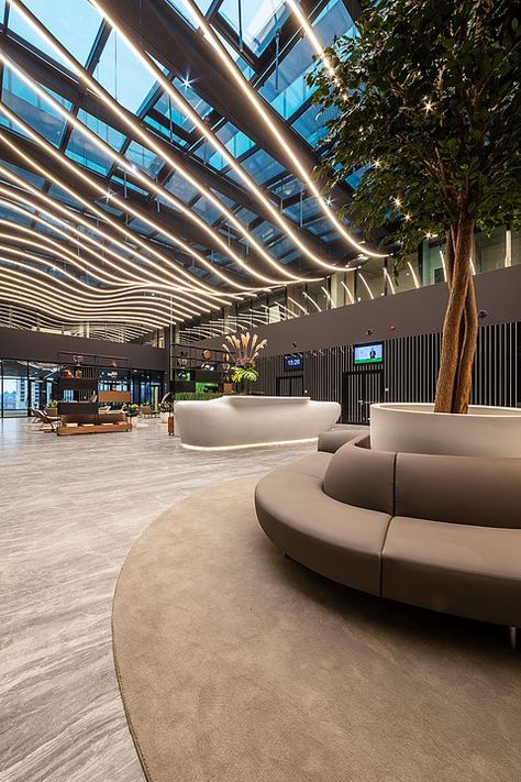 Grespania - Coverlam Medusa in Hillside Office Building Office Building Reception Lobby, Entertainment Building Design, Modern Atrium Design, Malls Interior, Lobby Decor Ideas, Atrium Lighting, Building Entrance Lobby, Lobby Ceiling Design, Office Lobby Design