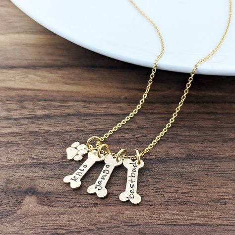 "Dog Bone Necklace, Dog Bone Charm, Dog Mom Gift, Dog Paw, Dog Charm Necklace, Dog Lover Necklace, Dog Lover Gift, Animal Lover Gift This is the perfect gift for the animal lover, A unique way to carry your loved ones close to your heart! ♥ this listing features: *gold dog bone charm with pets name *gold stainless steel chain  *gold paw charm *choose your name please indicate name in \"note to seller\" *choose number of tags please choose number of discs from the drop down menu." Paw Necklace, Lover Necklace, Adjustable Bangle Bracelet, Bone Necklace, Lovers Necklace, Gold Chain With Pendant, Dog Jewelry, Dog Charms, Adjustable Bangle