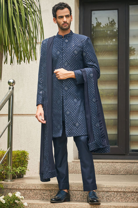 Featuring a navy blue sherwani in georgette base with chikankari embroidery. It is paired with a matching terry wool kurta, pants and a dupatta. Perfect wear for any festive occasions or wedding ceremonies. The Wedding Carnival up to 70 % off Wedding-ready to set you apart from the crowd.

#Perniaspopupshopmen #menswear #ethnic #whatiworewastrending #ppuslove #georgette #terrywool #chikankari #sherwaniset #embroidersherwani #weddingwear Navy Blue Sherwani, Indian Wedding Clothes For Men, Blue Sherwani, Kurta Pants, Georgette Kurta, Embroidered Sherwani, Chikankari Embroidery, Sherwani Groom, Sherwani For Men