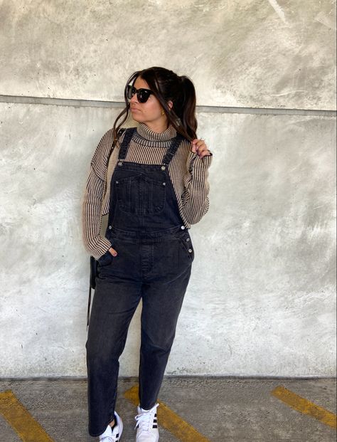 Brunette in high pony with quay sunglasses, brown cropped turtleneck sweater, black old navy overalls, and white adidas superstar sneakers Black Overalls Sweater Outfit, Corduroy Overalls Outfit Winter, Jacket Over Overalls, Overalls And Sweatshirt, Flannel Overalls Outfit, Christmas Overalls Outfit, Black Overalls Outfit Aesthetic, Black Overalls Outfit Winter, How To Style Overalls