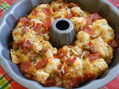 Easy Pull Apart Pizza Bread *2 (14 oz.) cans of Pillsbury pizza dough (you can use Grand biscuits) *2 cups shredded Mozzarella cheese *1/2 tbsp. basil leaves *1/2 tsp. dried oregano *1/2 tsp. fresh minced garlic *1/3 cup olive oil *1 (8 oz.) package of pepperoni (cut into quarters) *1 cup Parmesan cheese Pull Apart Cheese Bread, Pillsbury Pizza, Bundt Pan Recipes, Pizza Monkey Bread, Pull Apart Pizza, Pizza Bread Recipe, Bread Packaging, Canned Biscuits, Pizza Bites