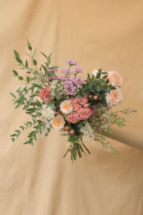 Our small hand-tied bouquet features a variety of our freshest seasonal blooms, finished with greenery. All hand-tied bouquets are wrapped in our signature paper wrapping and finished with raffia or ribbon. Choose between: Designer's choice >> Leave it to us to design a beautiful bouquet for you. Soft >> Soft, muted shades such as white, cream, blush, pale pink, and lavender. Bold >> Rich, vibrant shades such as yellow, purple, orange, red and pink. Pop of colour >> A mix of soft and bold: a viv Pink Flower Arrangements, Peach Bouquet, Prairie Flower, Red Bouquet Wedding, Hand Tied Bouquet, Prom Flowers, Paper Wrapping, Hand Bouquet, Bouquet Wrap