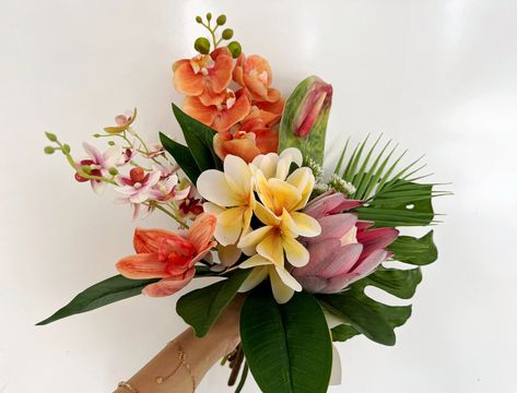 Colors orange, yellow, pink, green, etc. Flowers & Foliages plumeria, palm, protea, anthurium, monstera, etc. Material silk flowers, faux foliage, etc.  Introducing our exquisite Tropical Wedding Bouquet, an exquisite blend of vibrant colors and tropical blooms sure to add a touch of island paradise to your special day! This stunning arrangement features a perfect balance of plumeria, palm, protea, anthurium, and monstera leaves, each hand-selected to create an unforgettable bouquet. Radiating t Asian Flower Bouquet, Tropical Leaf Bouquet, Tropical Bohemian Wedding, Hawaiian Wedding Bouquet, Colorful Tropical Wedding, Tropical Flower Bouquet, Hawaii Wedding Flowers, Anthurium Bouquet, Plumeria Bouquet