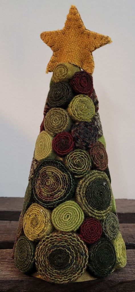 This festive tree is a lovely Christmas decoration that uses rich red and green wools that are 100% hand-dyed and have been washed and felted.  The finished tree measures approximately 3" x 7". Kit includes:  - precut wool strips  - precut wool star  - cone  - pattern  - assembly instructions Kit does not include adhesive. DISCLAIMER:  Materials in kits may vary from photo. Wool Trees Christmas, Wool Christmas Tree Diy, Cone Trees Christmas Diy, Rag Trees How To Make, Fabric Trees Christmas Diy, Fabric Christmas Trees Diy, Wool Quillies, Wool Trees, Christmas Tree Yarn