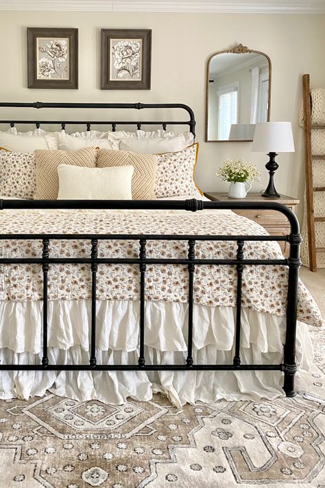 Summer farmhouse bedroom with neutrals and florals. A black iron bed, white and yellow floral bedding, and a neutral vintage inspired rug. Metal Bed Frame Bedroom Ideas Vintage, Summer Farmhouse Bedroom, Black Iron Beds, Wrought Iron Bed, Floral Farmhouse, Iron Bed Frame, Bedroom Redo, Relaxing Bedroom, Farmhouse Bedding