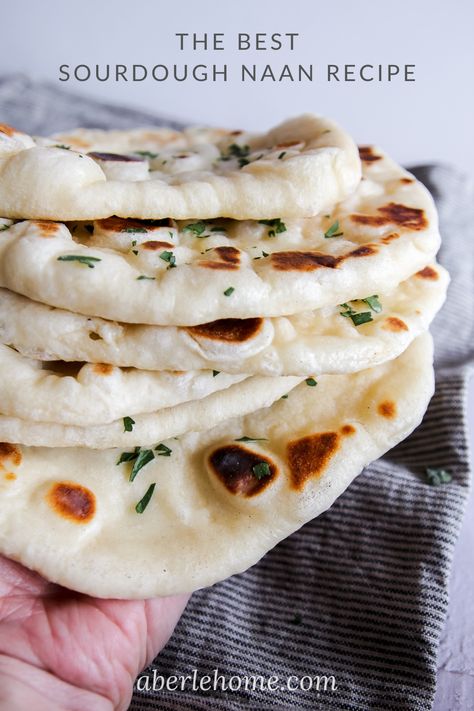 a hand holding a stack of fluffy, chewy sourdough naan flatbreads garnished with parsley Sourdough Naan Bread Recipe, Sourdough Naan Bread, Sourdough Flatbread Recipe, Sourdough Naan, Easy Naan Bread, Easy Naan, Naan Bread Recipe, Naan Flatbread, Recipes With Naan Bread