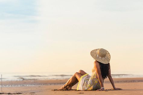 "Woman In A Dress With A Sunhat On Sitting On The Beach" by Stocksy Contributor "Cindy Prins" Woman On Beach Photography, Beach Portrait Poses, Beach Portraits Woman Photo Shoot, Sitting On Beach Pose, Beach Poses For Women, Varkala Beach Photography, Beach Sitting Poses, Goa Poses For Women, Beach Poses Dress