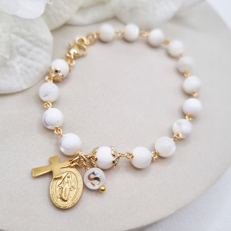 This dainty Rosary bracelet in natural Mother of pearl beads is a beautiful way to carry your faith with you every day. The elegant beads are complemented with unique letters in natural mother of pearls too, also handmade by me. Handcrafted with care and attention to detail, this bracelet is not only a stunning accessory but also a meaningful symbol of your spiritual journey. Whether it's a gift for yourself or a loved one, this rosary bracelet is a unique and thoughtful piece that will be treas Communion Wedding, Christian Bracelets, Rosary Bracelet, Letter Beads, Beads Handmade, Mother Pearl, Style Minimalist, Prayer Beads, Bracelet For Women