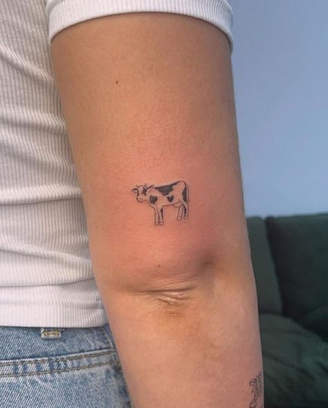 15. A small and simple cow tattoo Small Tattoo Body Placement, Dairy Cow Tattoo Ideas, Cow Silhouette Tattoo, Farm Life Tattoos, Cow Tattoo Fine Line, Minimal Cow Tattoo, Highland Cow Outline Tattoo, Funny Cow Tattoo, Arm With Small Tattoos