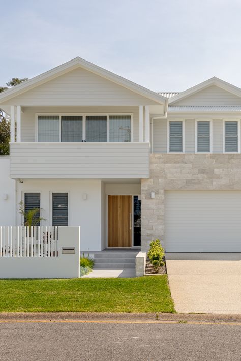 The Corlette House has been designed to fit comfortably within the surrounding context and is located within the popular holiday area of Port Stephens. The original house on the site was the families holiday home. The clients were retiring, and the brief was to create their forever home that could still accommodate their family on holidays. Weatherboard House Facade, Beach House Cladding, Fibro House Exterior, Cream Weatherboard Exterior, Beach House Contemporary, Beachy Home Exterior, House Facades Australia Double Storey, Hamptons Exterior House, Beach House Exterior Australian