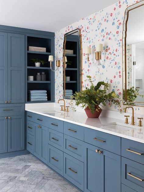 A blue shaker double vanity dons brass pulls and antique brass faucets mounted beneath French mirrors lit by glass and brass sconces and hung from a wall covered in Lake August Nasturtium wallpaper. Herringbone Bathroom Floor, Blue Hexagon Tile, Antique Brass Bathroom Faucet, Marble Herringbone Floor, Antique Brass Faucet, Polished Nickel Faucet, Marble Herringbone, Blue Shelves, Brass Bathroom Faucets