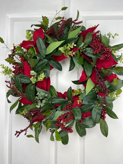 "This Christmas wreath is sure to  any door this holiday season!  Made with green leaves, poinsettia leaves, eucalyptus and red berries. Don't miss out, get one today! Approximate Diameter: 23\" This wreath was created using a high quality materials on a grapevine base measuring 18 inches Indoor/ Sheltered Outdoor safe Adjustable wire loop added to the back of the wreath for easy hanging. To see more Christmas wreaths in my shop: https://www.etsy.com/shop/TheSplendidDoor?ref=seller-platform-mcnav&section_id=30865848 To see all wreaths in my shop: https://www.etsy.com/shop/TheSplendidDoor?ref=seller-platform-mcnav" Red Floral Wreath, Christmas Poinsettia Wreath, Christmas Large Wreath, Decorated Christmas Wreaths, Christmas Flower Wreaths, Easy Diy Christmas Wreaths, Beautiful Christmas Wreaths, Christmas Floral Wreath, Scandi Wreath