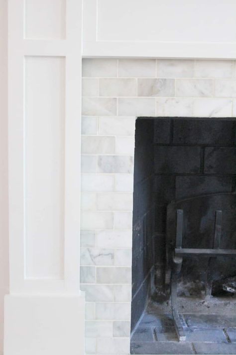 An outdated brick fireplace is resurfaced with marble tiles. Reface Brick Fireplace, Window Nooks, Mantle Makeover, Tile Styles, Hearth Tiles, Brick Hearth, How To Tile, Diy Fireplace Makeover, Fireplace Bookshelves