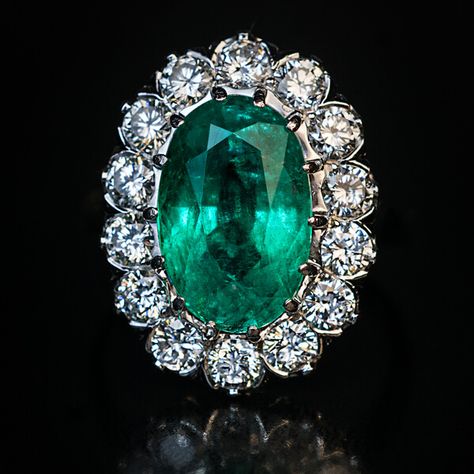 This mid-century vintage French emerald and diamond engagement cluster ring is finely crafted in platinum (head) and 18K white gold (shank). The ring features a sparkling medium green natural emerald likely of Colombian origin.  The oval cut emerald measures 12.62 x 8.15 x 6.30 mm and is approximately 3.59 ct.  The brilliant cut diamonds are bright white (E-F color) and clean (mostly VS clarity). Estimated total diamond weight is 1.40 ct.  The ring is marked with eagle’s head and dog’s head Fren Emerald Diamond Engagement Ring, Jewelry Closet, Diamond Tops, Emerald Ring Engagement Diamond, Emerald Ring Vintage, Luxury Engagement Rings, Faberge Eggs, Engagement Ring Diamond Cut, Emerald Jewelry