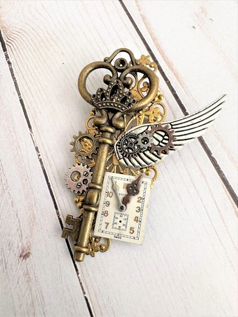 Three styles, each One of a Kind Steampunk Brooches. See the creative choices in these unique brooches. Each brooch is made with a large brass old fashion key, on gold filigree. Each brooch has a one of a kind unique clock face, and each have a large silver metal wing, and an assortment of Gears. They each have a pin on the back. Each brooch is about 3.5 inches tall, and 2.5 inches wide. These Steampunk brooches can be a part of your collection of Steampunk Jewelry. Great unisex jewelry for wom Steampunk Accessories Mens, Unique Brooches, Old Fashioned Key, Steampunk Items, Steampunk Aesthetic, Steampunk Halloween, Arte Steampunk, Metal Wings, Style Steampunk