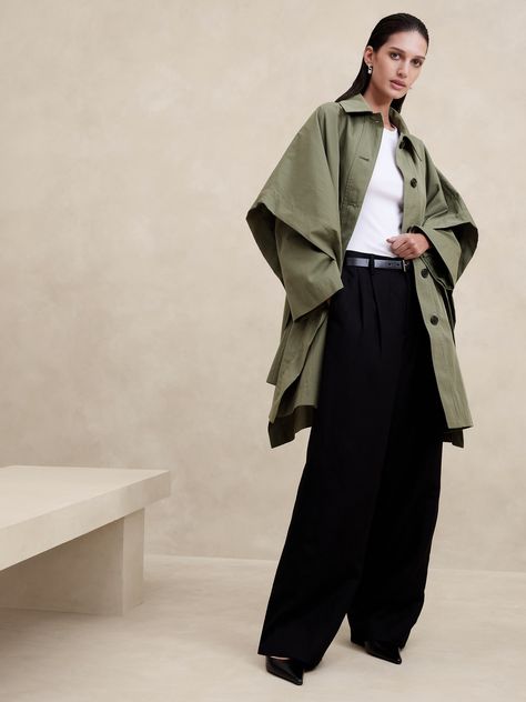 We built this dramatic silhouette by blending a traditional draped cape with the styling details of a classic Mac coat: a pointed collar, button front and integrated long sleeves.  Cut from a beautiful cotton-nylon fabric with a water-repellant coating to keep the elements at bay.  Warmer: Lightly lined so you can layer it through the seasons.  Oversized fit.  Point collar with button-front.  Two exterior pockets and one interior pocket at the chest.  Fully lined.  Oversized fit.  Long sleeves. Poppy Images, Mac Coat, Fashion Week Trends, Top Street Style, Street Style Trends, Cape Coat, Spring Jackets, Khaki Green, Oversized Fits