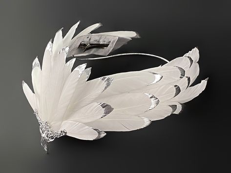 A unique tiara made from a natural feather, coated with liquid plastic at the ends and painted with chrome-plated silver paint. The center of the crown is decorated with a metal element with a pendant. This headpiece will complement any White Swan, White Raven, White Eagle, Firebird, Bird of Paradise, Phoenix or Goddess costume you desire. It will be a great addition to a photo shoot, festival or party, Halloween party. The headpiece is attached to the hair with hair clips and elastic band. The White Swan Headpiece, Feather Costume Ideas, Feather Headpiece Diy, Raven Headpiece, Swan Costume Diy, Swan Headpiece, Bird Headdress, Bird Headpiece, Wings Headpiece