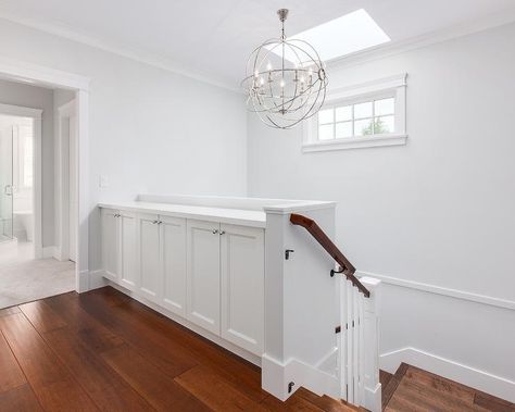 A staircase with skylight leads to a second floor landing fitted with built-in cabinets illuminated by a Crystorama Solaris 6 Light Chandelier. Landing Storage, Bookcase Stairs, Top Of Stairs, Upstairs Landing, Staircase Landing, Second Floor Landing, 80s Home, Built In Cabinet, Entrance Foyer