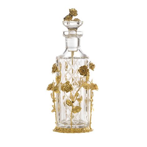 Symbol of love and romance, gilded roses dance along this mouth-blown crystal bottle engraved by hand with a diamond pattern that enhances its luminous and evocative quality. Handcrafted by master artisans, the bottle (450 ml) rests on a round base and is surrounded by exquisite long-stemmed roses of lost wax casting bronze illuminated by a mirror-polished 24k gold plating. The stopper showcases a bouquet of roses and is equipped with a stick applicator. Available also in amber crystal, silver p Rose Perfume Bottle, Elegant Perfume Bottles, Luxury Perfume Bottle, Uni Vibes, Fun Beauty Products, Rose Gold Clothes, A Bouquet Of Roses, Crystal Bottle, Perfume Bottle Design