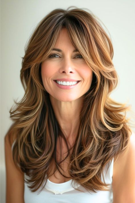 Embrace the volume with these luxurious layered curls with curtain bangs, a hairstyle that's all about depth and dimension. The rich, flowing locks are a testament to timeless beauty, and the playful bounce of the curls adds a touch of fun to any look. Click here to see more stunning hairstyles for women over 40. Long Curtain Bangs Medium Hair Curly, Jacklyn Smith Hairstyles Today, Hair Layers With Curtain Bangs, Long Blonde Hair With Curtain Bangs, Hairstyles With Layers And Bangs, Curtain Bangs On Long Hair, Long Layered Hair Cut, Long Hair With Curtain Bangs, Curtain Bangs Hairstyle