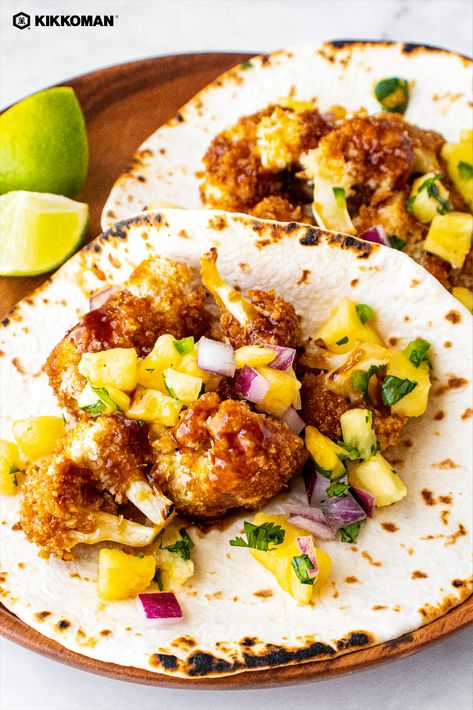 Image shows 2 soft tacos on a wooden plate with lime wedges off to the side. Each taco has a few Panko-breaded cauliflower florets with a scoop of bright yellow pineapple salsa on top. There is a Kikkoman logo at the top left corner of the photo. Breaded Cauliflower Tacos, Hawaiian Vegetarian Recipes, Tropical Dinner Recipes, Luau Brunch, Hawaiian Tacos, Hawaiian Appetizers, Pineapple Tacos, Homemade Dipping Sauce, Tacos Tuesday