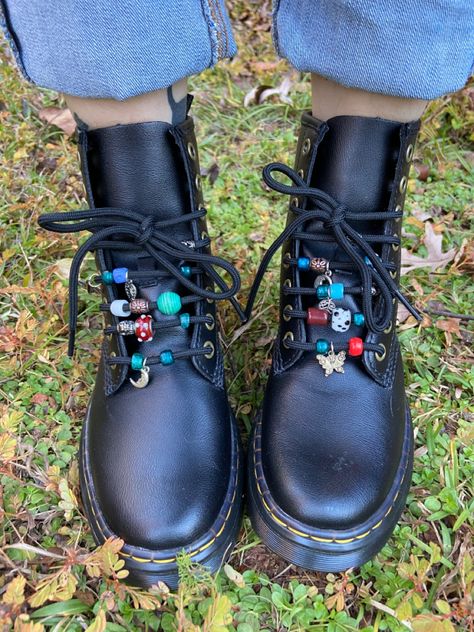 Black doc marten boots with different colored glass beads on the laces Diy Doc Martens Charms, Doc Martens Beads On Laces, Doc Marten Ribbon Laces, Upcycled Doc Martens, Decorating Doc Martens, Doc Martens Beads, Beaded Doc Martens, Dr Martens Accessories, Doc Marten Accessories