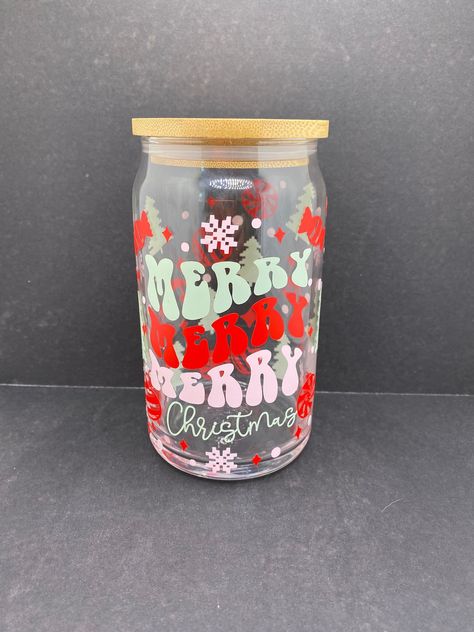 🎄 Merry Merry Merry Christmas 16 ounce Libbey Glass 🎅🏽 The perfect cup for your holiday beverages! From iced coffee to bottled bubbly this cup can hold it all. This holiday-themed cup is cute and the perfect spooky accent for your holiday decor.  ⭐️ Libbey 16 oz. glass can jar ⭐️ Decal is made with permanent vinyl ⭐️ COMES WITH STRAW AND LID 🧽 CUP CARE * Not dishwasher safe * Not microwave safe * Hand wash only * Avoid extreme heat * Do not soak! 📦 SHIPS FREE TO ANYWHERE IN USA 📦 Diy Christmas Tumblers, Christmas Cup Svg, Christmas Libbey Cup, Christmas Cup Ideas, Christmas Vinyl Ideas, Christmas Cups Vinyl, Holiday Beverages, Beer Glass Cups, Bamboo Cups