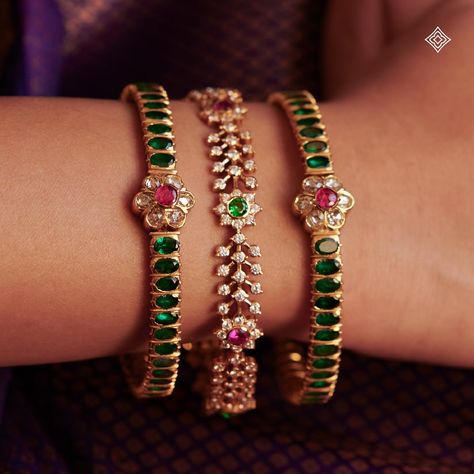 As a bride dons these exquisite bangles, she is not only adorned in beauty but also enveloped in the blessings and legacy of her ancestors, making her journey into married life even more sacred and memorable. Seen here are our 22K emerald kada-style bangles and floral motif stone bangles, each glistening with hints of rubies. WhatsApp 9964641869 for enquiries. 📍Visit the Blue CKC&Co. Flagship store , near Safina Plaza. Look for the DIAMOND logo! Featuring: @@lepana_nagaraj Saree: @aikyath... Stones Bangles In Gold, Black Beads Bangles, Emerald Bangles, Dressy Jewelry, Stone Bangles, Ruby Bangles, Bangle Design, Gold Temple Jewellery, Gold Earrings Models