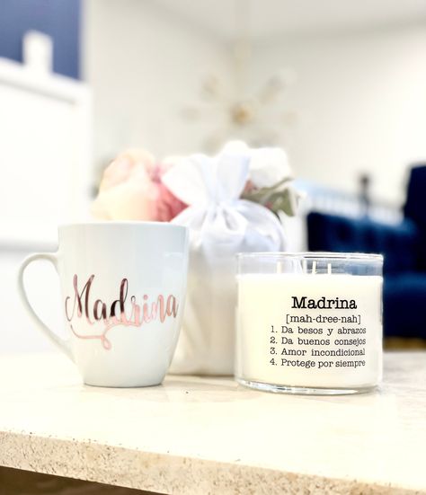 Adorable Madrina proposal!  *WHAT YOU GET* 1 Madrina Candle 14.5 oz 1 Madrina Mug 1 White/off white Muslin Drawstring Bag Please note that all letters on drink ware will be in lower case letters. High quality outdoor vinyl is used to create lettering. This is not a painting or subliminal design.  Mug is not dishwasher/microwave safe. Hand-wash only, towel dry Candle Highlight Aromatherapy Eucalyptus + Sage Soy-Based Premium Wax In Glass Jar Approximate Burn Time Of 50 Hours Candle fits nicely in Subliminal Design, Gifts For Godmother, Godmother Proposal, Clear Labels, Best Hug, Drink Ware, Godmother Gifts, Design Mug, Satin Bags