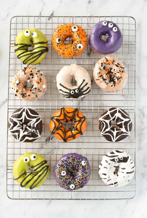 Create the cutest, easy Halloween Donuts using store bought donuts, homemade glaze, candy eyes. They are guaranteed to be the hit of your Halloween party. Halloween Mini Doughnuts Ideas, Decorate Donuts Ideas, Halloween Donuts With Teeth, Halloween Doughnuts Ideas, Halloween Donuts Ideas, Halloween Candy Ideas, Donut Halloween, Cute Halloween Cakes, Cake Pucks