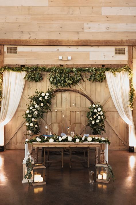 Sweetheart table with circular arch, cascading greenery and candlelight. Wedding barn in upstate New York. Sweetheart Table Decor Rustic, Head Table Flower Garland, Round Head Table Wedding, Sweetheart Table With Backdrop, Sage Sweetheart Table, Rustic Sweetheart Table Decor, Spring Sweetheart Table, Wedding Arch Sweetheart Table, Bridal Party Table Ideas