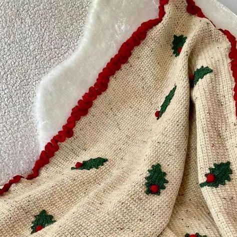 Kate Eastwood on Instagram: "This Christmas blanket is the newest one to be added to the pile as I designed it for my book Crochet with Flowers and Plants which came out last year. The main part of the blanket is in simple dc, using a thick and cosy yarn, making it a lovely speedy make. The holly leaves are crocheted separately and stitched on to the finished blanket, and they each have the tiniest sparkle to them. #crochetblanket #christmascrochet #crochet #christmas #holly" Crochet Christmas Tree Blanket, Crochet Blanket Christmas, Things To Crochet With Red Yarn, Christmas Blanket Crochet, Crochet Holly, Crochet Christmas Blanket, Crochet Poinsettia, Book Crochet, Christmas Crochet Blanket