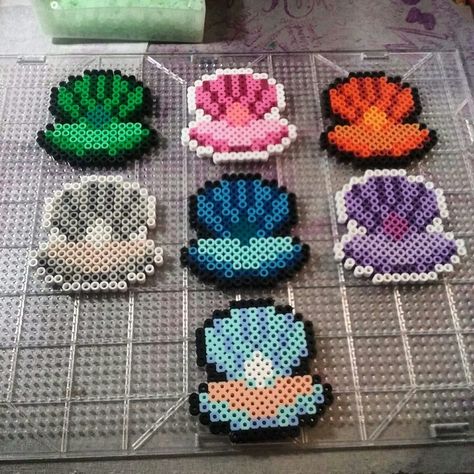 Les contours blanc du coquillage violet seront en orange foncé, les contours du coquillage rose seront en vert clair, les contours du coquillage gris seront en rouge Aesthetic Fuse Bead Patterns, Shell Perler Beads, Beach Perler Beads, Ocean Perler Beads, Perleplader Ideas Cute, Perleplader Ideas, Melty Bead Designs, Melt Beads Patterns, Hamma Beads Ideas