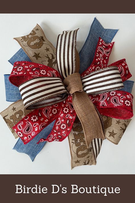 Western theme bow with natural, blue denim, red & brown colors. It is made from five different ribbons that all coordinate. Add this to a lantern, light, door, mailbox or anywhere in your home for a pop of color. Do you have a wreath that needs an update? Add this to the design to freshen and update the look. #birdiedsboutique1 #etsyshop #handmade #westernbow #rodeobow #rodeoribbon #westerndecor #redbandanaribbon #neutralbluered #lanternbow #mailboxbow #bowforwreath #bow Bow For Wreath, Mailbox Bow, Wreath Door Hanger, Homemade Bows, Bandana Pattern, Farmhouse Crafts, Fall Bows, Western Rodeo, Wreath Door