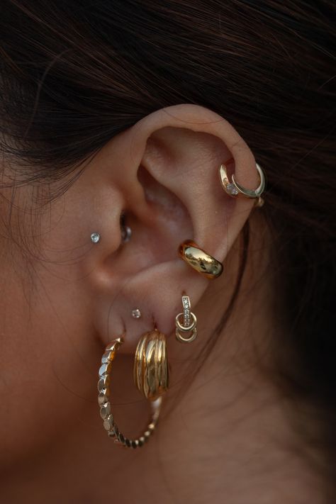 Like the rings that revolve around Saturn, these unique hoops feel like a triple threat - featuring three small hoop accents (that even move!), CZ crystals, and a perfectly sized solid gold hoop for your stack. We've never seen a hoop with as many unique elements as this, and we swear there's nothing like it. 14k Solid Gold Set with cubic zirconia crystals Dimension: 10 mm, 1.45 g Handcrafted in Italy Sold INDIVIDUALLY, not as a pair Conch Piercing Hoop Chunky, Opal Ear Styling, Piercing Gold Ear, Ear Ring Stack, Mixed Metal Ear Stack, Mixed Metals Earring Stack, Pierced Ears Ideas, Ear Piercing Set Up, Earring Placements