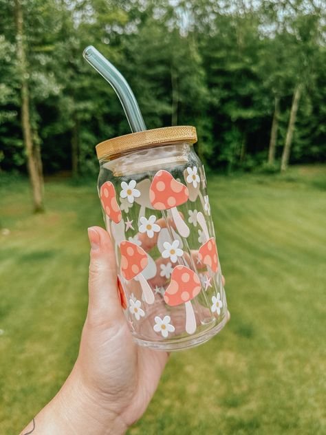 This trendy glass is the perfect vibe for the warmer weather! The glass pictured below is 16oz. All of our cups are made with permanent uv decals and come with a bamboo lid & reusable glass straw. All glasses are handwash only and come with care instructions in each package! This item is made to order and is not eligible for return. If you have any questions about your order, please reach out to us at bidwellbydesign@gmail.com. Pretty Glass Cups, Mushroom Glass Cup, Glass Cups With Bamboo Lids Designs, Cute Glass Cup Designs, Vasos Aesthetic, Preppy Cups, Mushroom Cups, Cute Glass Cups, Glass Cup With Straw