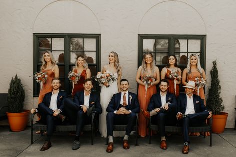 Burnt Orange And Navy Bridal Party, Burnt Orange Wedding Attire, Wedding Party Photos Navy Suits, Rust Wedding Theme Groomsmen, Burnt Orange Bridesmaid Dresses With Groomsmen, Terracotta And Navy Wedding Bridesmaid Dress, Rust Wedding Attire, Navy And Burnt Orange Groomsmen, Dark Navy Suit Wedding Color Combos