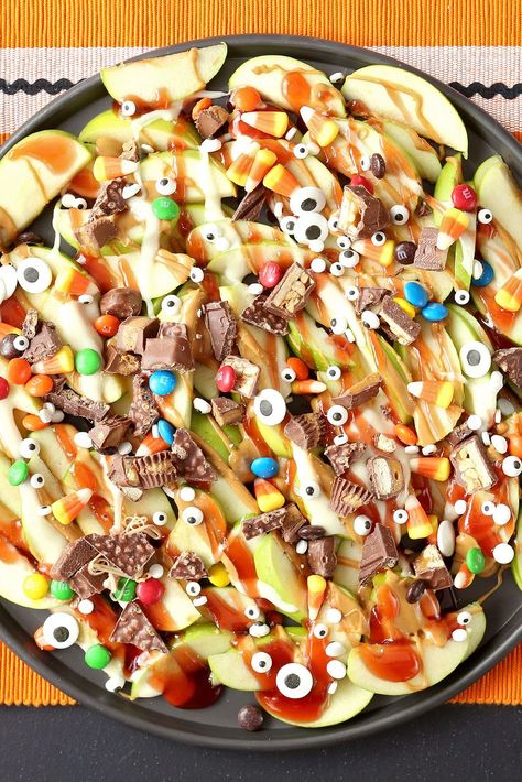 Put all that Halloween candy to good use by whipping up a tray of these dessert nachos. Top sliced Granny Smith apples with melted peanut butter, jelly, and chopped chocolate candy. A sprinkle of candy eyes adds a spooky touch. #halloweenrecipes #halloweentreats #halloweensnacks #halloweenpartyfood #bhg Halloween Potluck Recipes, Halloween Food Snacks, Halloween Potluck, Dessert Nachos, Halloween Finger, Easy Halloween Treats, Halloween Finger Foods, Finger Foods For Kids, Halloween Charcuterie