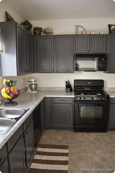 how to decorate a kitchen with black appliances and dark gray painted cabinets Charcoal Gray Kitchen Cabinets, Grey Cupboards, Kitchen Cabinets Before And After, Black Appliances Kitchen, Kabinet Dapur, Black Appliances, Gray Cabinets, Kitchen Colour Schemes, Kitchen Cabinets Makeover