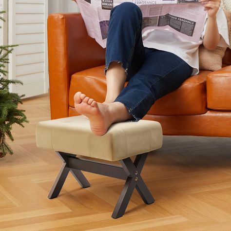 PRICES MAY VARY. RESTING FOOT STOOL: This comfortable foot rest features a thickly padded foam cushion top covered in velvet fabric. Its X-design solid wooden legs ensure stability. Resting your bare feet on the small ottoman helps relieve tension and reduces pressure on your legs. STURDY & PROTECTIVE: This ottoman foot rest's solid wood frame supports up to 300 lbs, guaranteeing long-lasting use. Its legs feature anti-skid pads to prevent sliding while protecting your floors from scuffs and scr Mid Century Foot Stool Ottomans, Leg Rest Stool, Small Ottoman Foot Stools, Top Of Cabinets, Foot Rest Ottoman, Small Ottoman, Tension Relief, Small Stool, Couch Chair