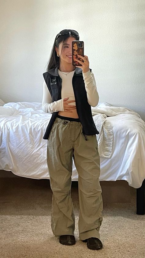 fall outfit idea with arcteryx black zip up vest and white long sleeve green baggy parachute cargo pants aesthetic gorpcore Green Parachute Pants Outfit, Arcteryx Outfit, Cargo Pants Aesthetic, Parachute Pants Outfit, Baggy Pants Outfit, Pants Aesthetic, Parachute Cargo Pants, Parachute Cargo, Zip Up Vest