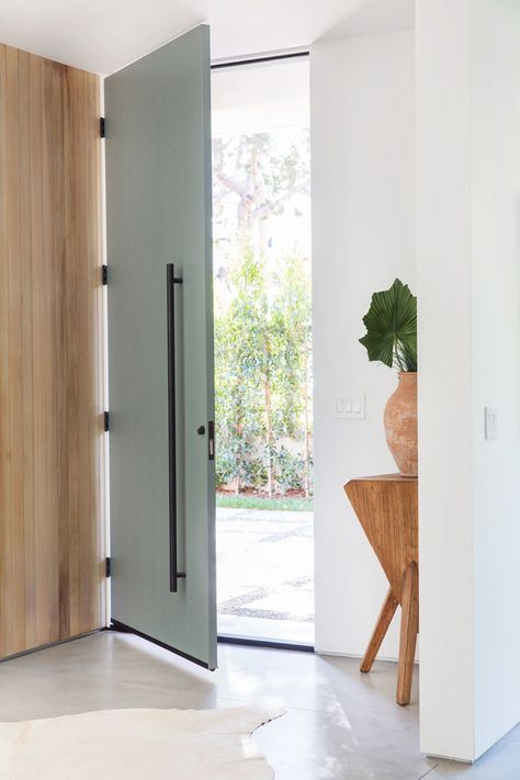 A tall, full-height grey front door with matte black hardware welcomes visitors to this mid-century inspired home. #FrontDoor Scandinavian Doors, Scandinavian Door, Grey Front Door, Green Front Door, Minimalist Entryway, Front Door Ideas, Front Door Hardware, Green Front Doors, Modern Front Door