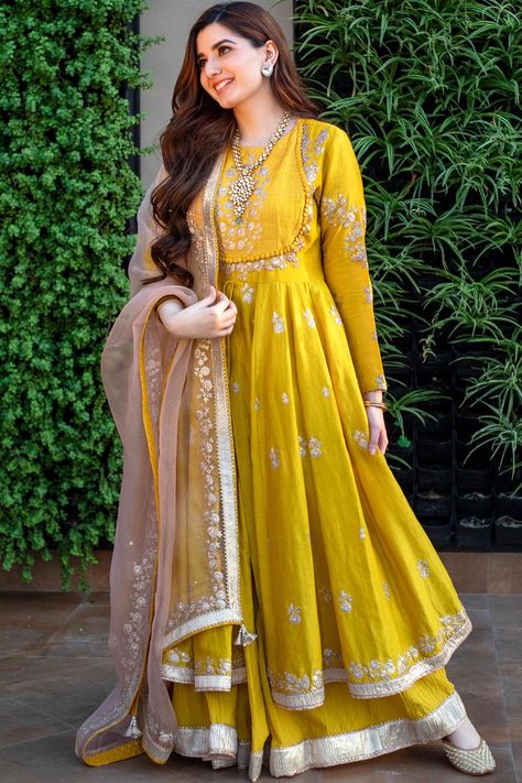 Featuring a glaze mustard anarkali in silk chanderi base with kashmiri tilla, pearls, and gota embroidery. It is paired with a matching crushed cotton skirt and a daisy ivory silk organza dupatta.The biggest luxury blowout end of season sale up to 50% off Anarkalis to Adore.#Perniaspopupshop #womenswear #ethnic #whatiworewastrending #ppuslove #anarkaliset #organza #chanderisilk #cotton #gotaembroidery #pearlsembroidery #weddingwear #festivewear #sangeet #haldi #weddingceremony Long Frock Suit, Indian Long Frocks, Bridal Anarkali, Anarkali Churidar, Haldi Outfits, Designer Anarkali Dresses, Anarkali Dresses, Suit Ideas, Pakistani Fancy Dresses