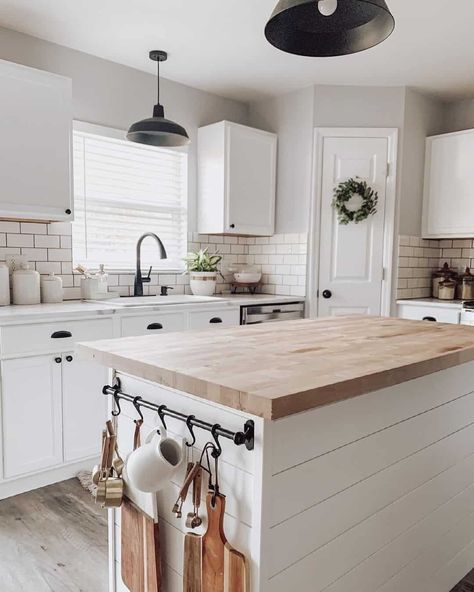 A modern farmhouse kitchen with greige walls and white cabinets features a white island with an ash butcher block countertop. Two black metal pendant lamps hang from the ceiling. The backsplash is of white subway tile...   Image: _littlebitofgrace_ Kitchen With Butcher Block Island, Butcher Block Countertops Kitchen, Two Toned Kitchen Cabinets, Trend Kitchen, Butcher Block Kitchen Island, Greige Kitchen, Butcher Block Island Kitchen, Kitchen Cabinets Ideas, Butcher Block Kitchen