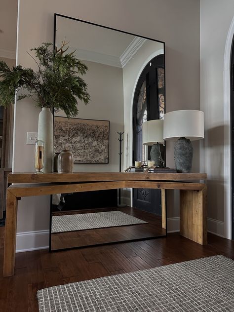 Rustic entry way interior design. Entry rug. Wood console table. Table is styled with books, vessles, greenery, beads and a table lamp. Oversized mirror is behind the console. Nashville Interior design. Vstupná Hala, تصميم الطاولة, Rustic Luxe, Future Apartment Decor, Hall Decor, Home Entrance Decor, Hus Inspiration, Wood Console, Large Mirror