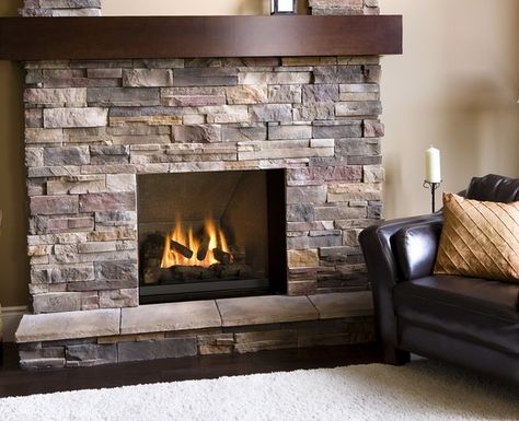 gas fireplace stone veneer ideas airstone wooden mantel leather armchair Airstone Fireplace, Stone Electric Fireplace, Indoor Gas Fireplace, Stone Veneer Fireplace, Stone Veneer Wall, Design Camino, Stacked Stone Fireplaces, Stone Fireplace Surround, Brick Fireplace Makeover