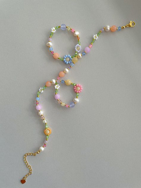 This necklace features white, yellow, green, orange, pink, periwinkle, lavender, and 24k gold plated seed beads. It also contains pink, green, purple, orange, yellow, and blue crystal beads. As well as freshwater pearls, purple, pink, blue, and orange jade, lavender amethyst, honey calcite, selenite, . Length: 16.5-18.5 inches Seed Bead Size: 11/0, 6/0, 2mm, 4mm, 6mm Adjustable: Each necklace has a 2" 18k gold filled lobster clasp extender Strung on: Non-Stretchy Beading Thread Please note: gems Trendy Bead Necklace, Pink Seed Bead Necklace, Diy Seed Bead Jewelry, Bead Necklace Designs, Flower Bead Necklace, Beaded Flower Necklace, Purple Beaded Necklace, Craft Necklace, Seed Beads Necklace