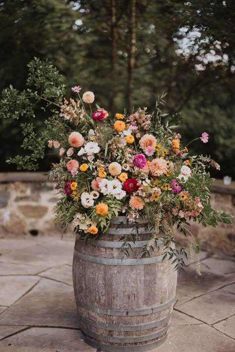 Bright pastels and wildflowers come together in perfect harmony at the Inn at Grace Winery wedding. The wedding features breathtaking floral designs that encapsulate the essence of a romantic vineyard wedding. Get inspired for your big day with florals that are as vibrant and joyful as your love story! Wedding Ideas Winery, Wedding Flowers On Barrels, Romantic Flowers Wedding, Country Wildflower Wedding, Spring Vineyard Wedding, Texas Wildflower Wedding, Wildflower Floral Arrangements, Western Wildflower Wedding, Meadow Wedding Flowers